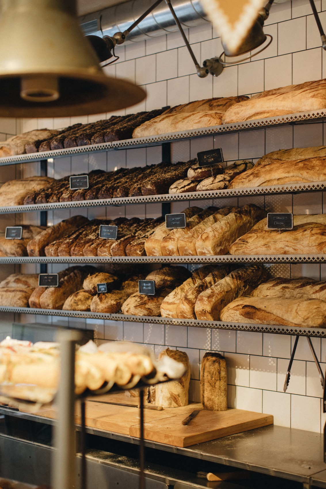 The shelf of the day's bread behind the counter, kind after kind.